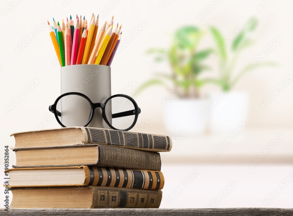 Stack of vintage books and colorful pencils on the desk