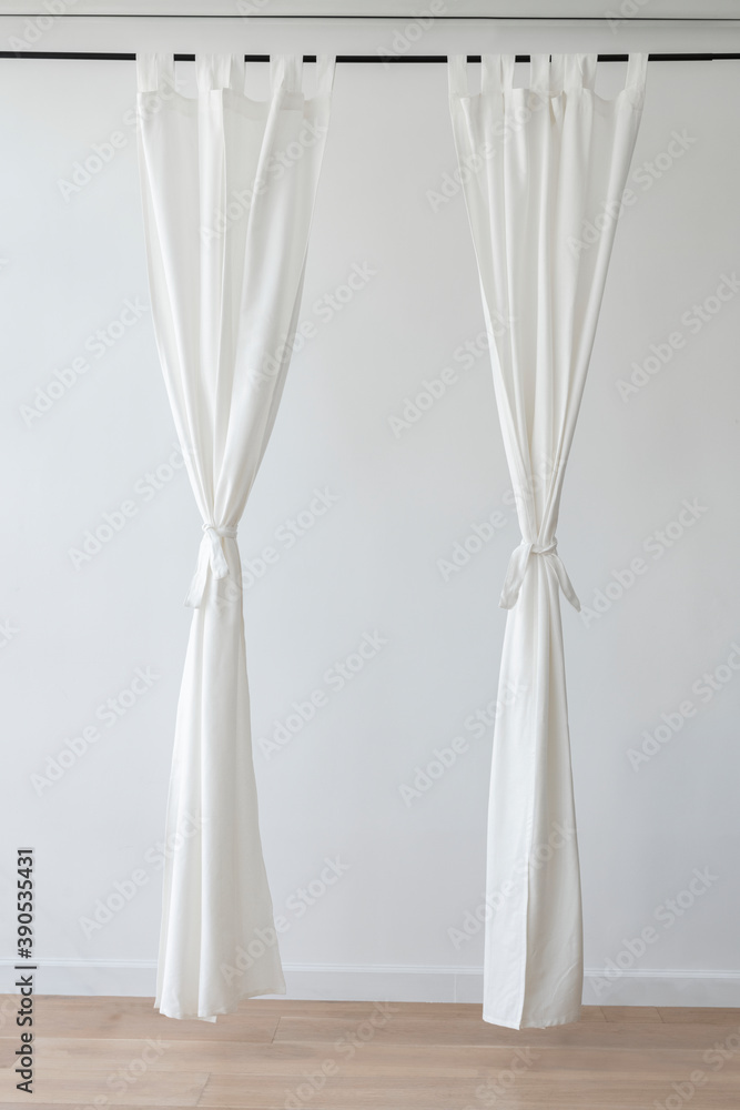 White drapery hanging from a curtain rod