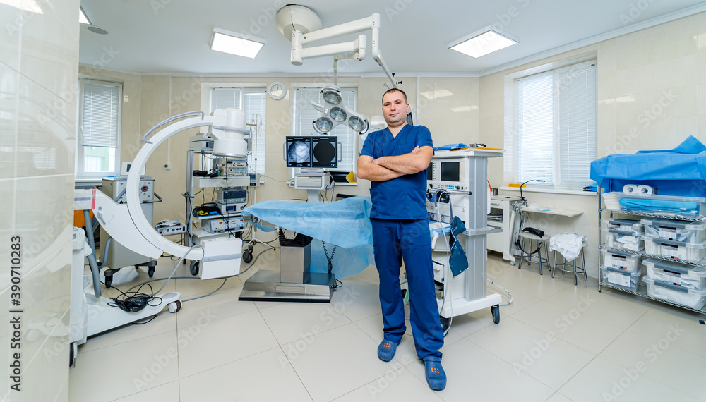 Portrait of a male surgeon at work. Modern surgery room at clinic. Professional doctor in up to date