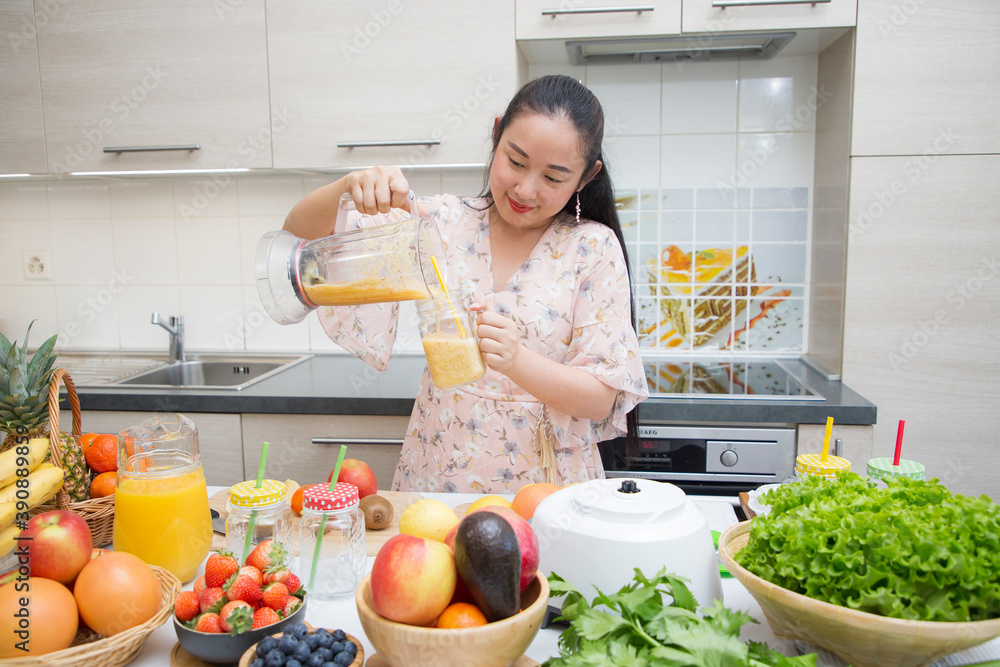 快乐的女人喜欢用新鲜的水果和蔬菜做早餐奶昔