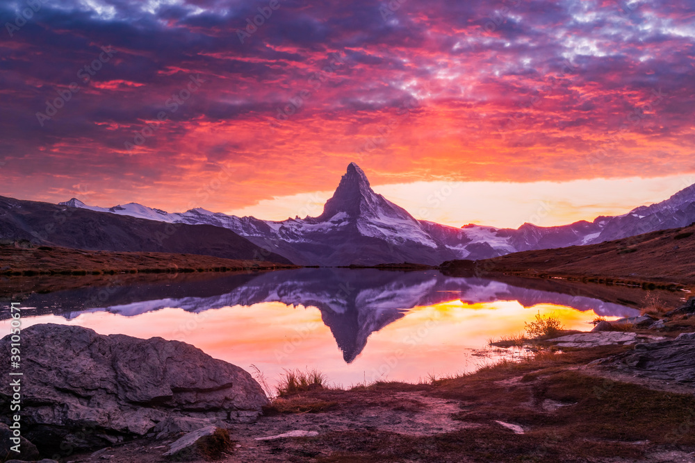 Splendid landscape with colorful sunrise on Stellisee lake. Snowy Matterhorn Cervino peak with refle