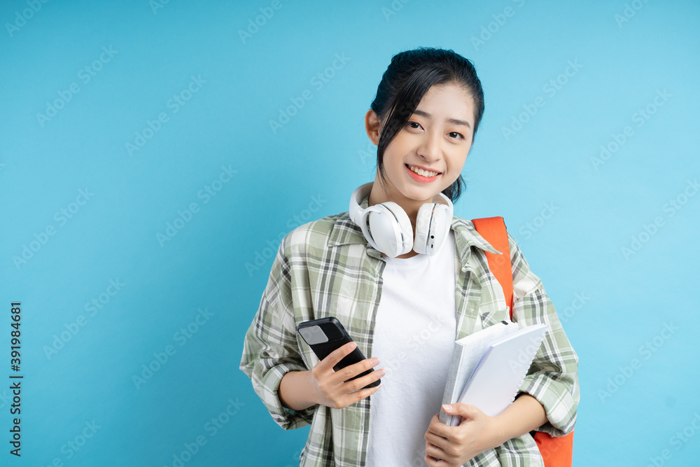 students holding books and phones are smiling happily