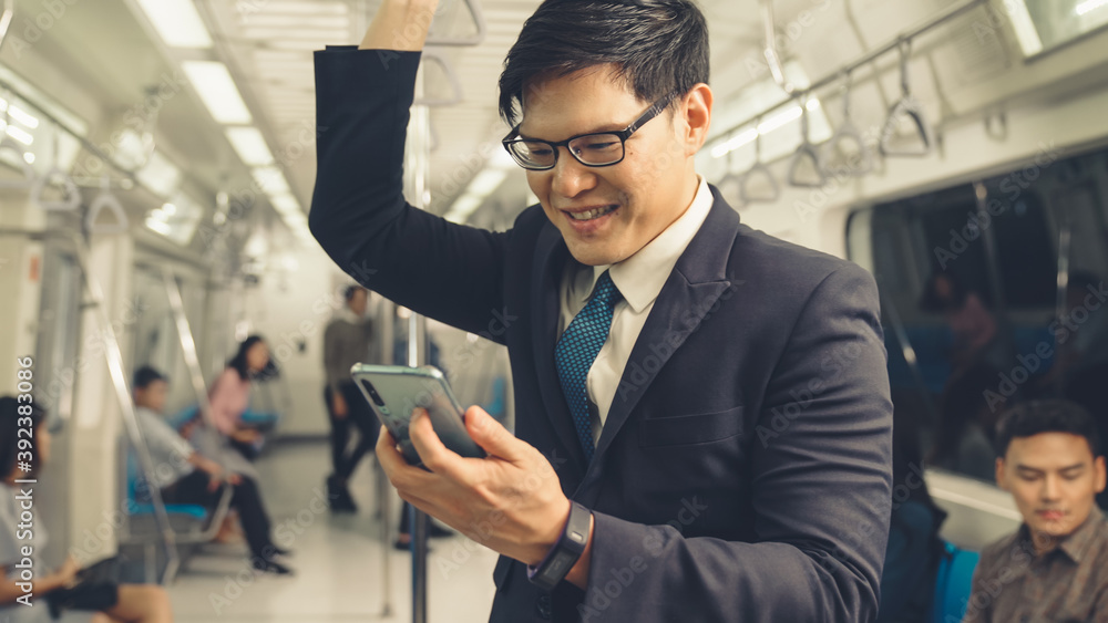 Businessman using mobile phone on public train . Urban city lifestyle commuting concept .