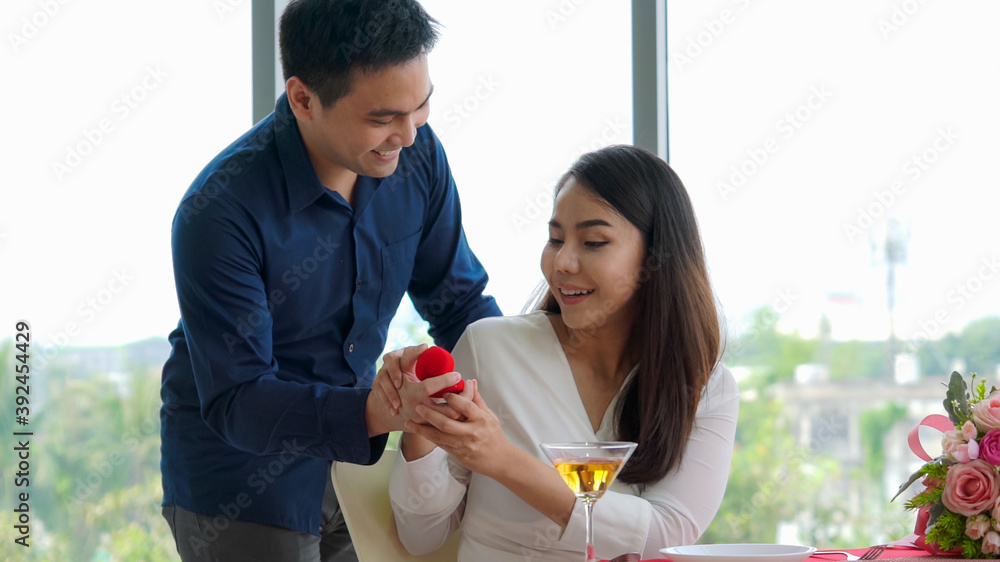 Romantic couple giving gift to lover at restaurant . Happy couple lifestyle .