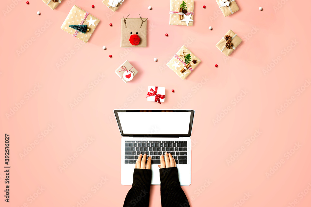 Person using a laptop computer with Christmas gift boxes from above