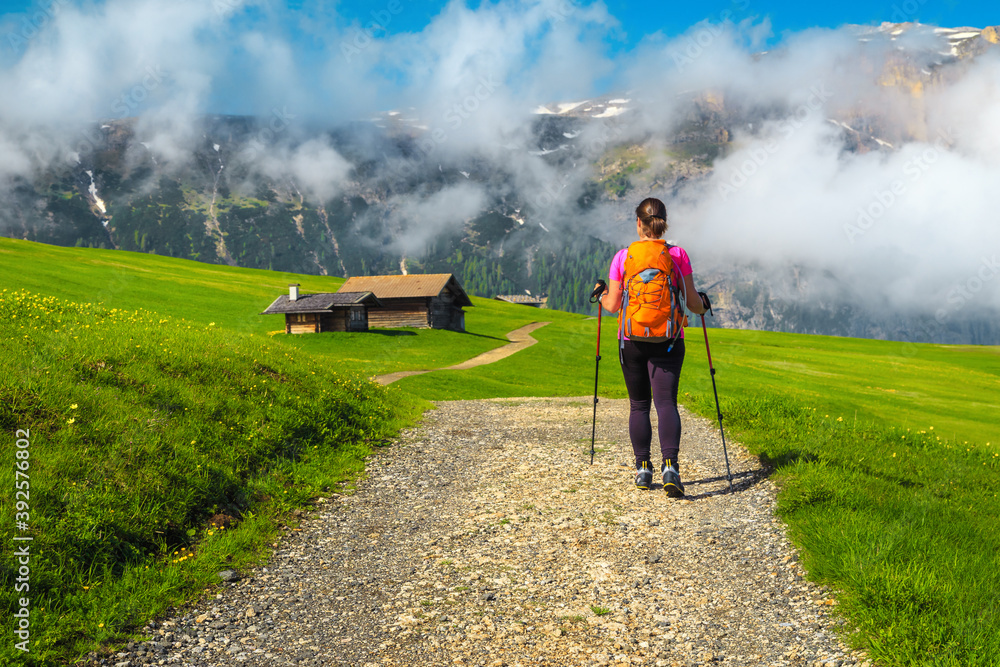 Sporty woman with backpack on the hiking trail, Dolomites, Italy