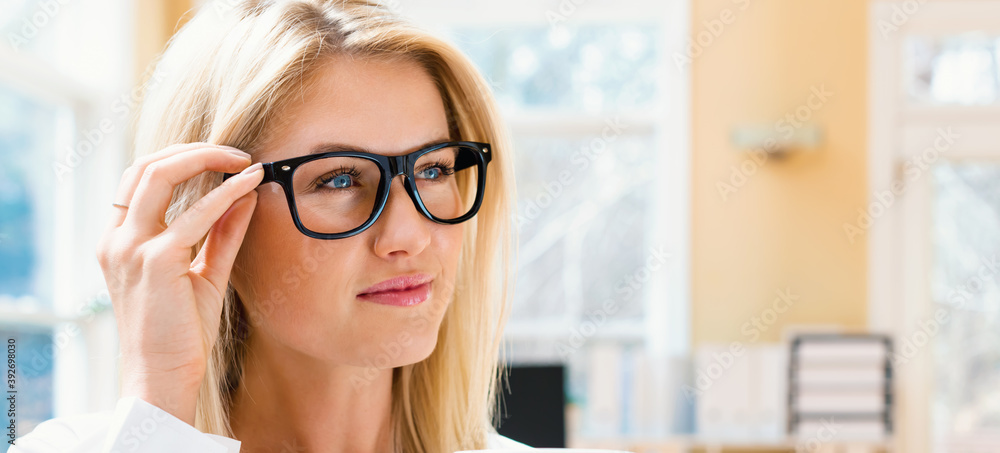 Happy young woman drinking coffee in an office