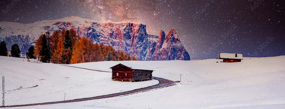 amazing winter landscape at night with small cottage