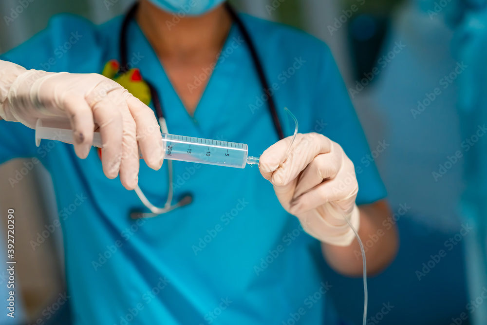 Doctor adjusts medical dropper with medicine in surgery room. Selective focus on hands.