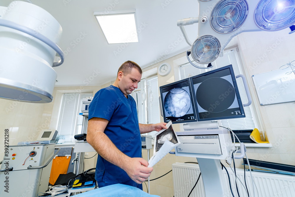 Portrait of a male surgeon at work. Modern surgery room at clinic. Professional doctor in up to date