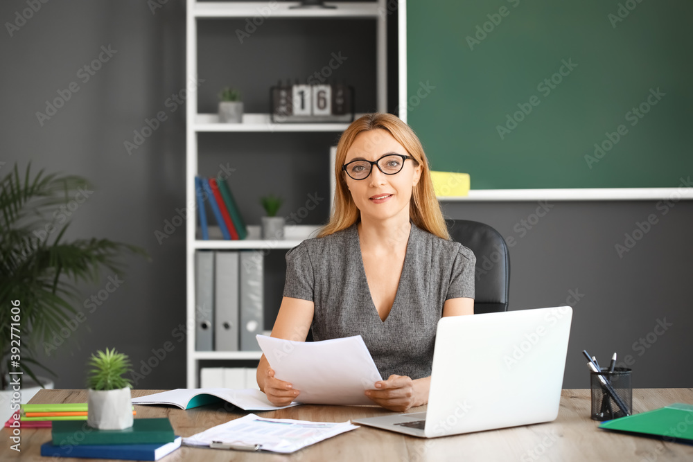 Mature female teacher working in classroom