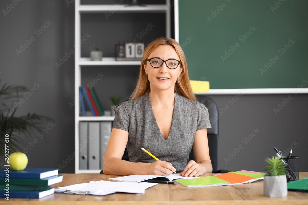 Mature female teacher working in classroom