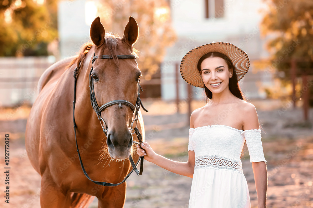 Beautiful young woman with cute horse outdoors