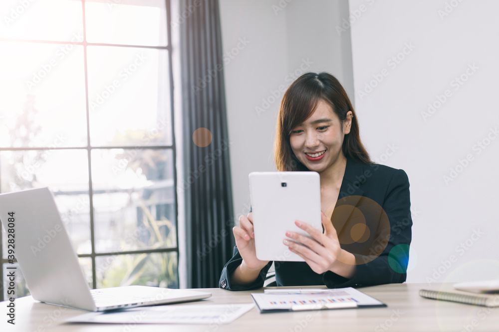 一名亚洲女性戴着耳机，玩着平板电脑交流、听课、学习