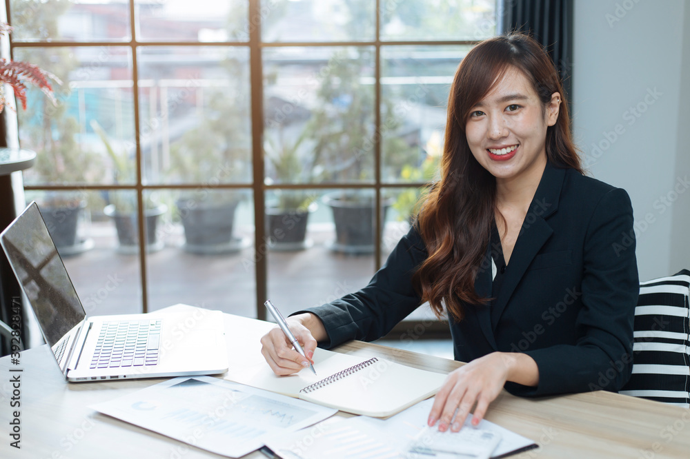 一位女商人坐在电脑桌上，手里拿着一份纸质计划、商业计划、在家办公的会议