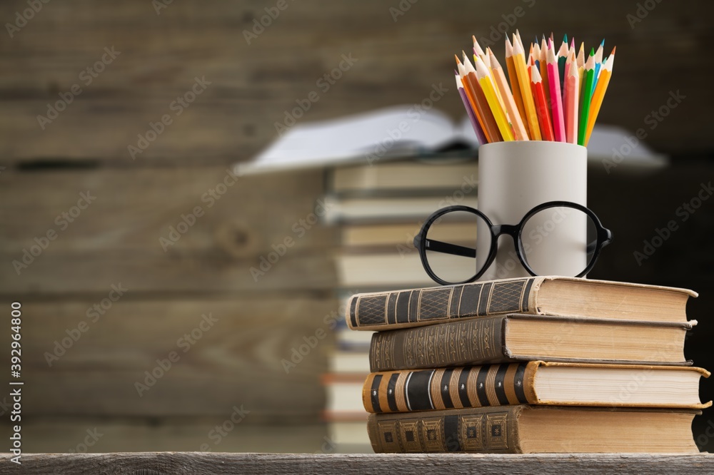 Stack of vintage books and colored pencils on the desk