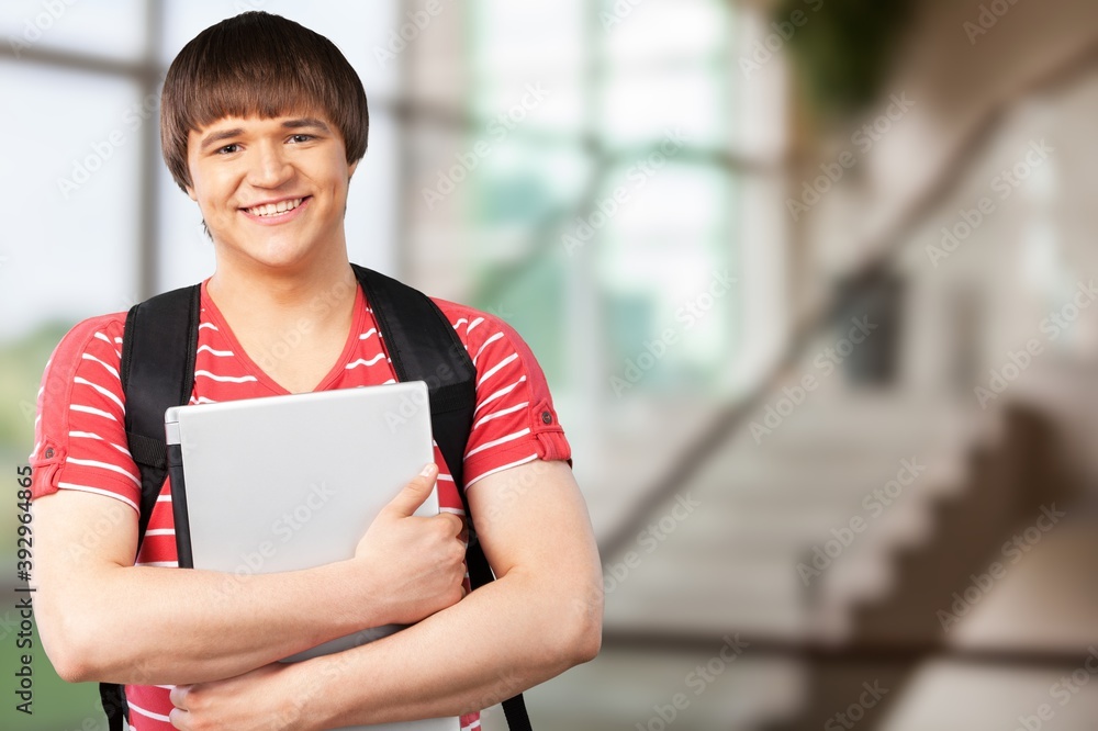 Smiling young college student with laptop