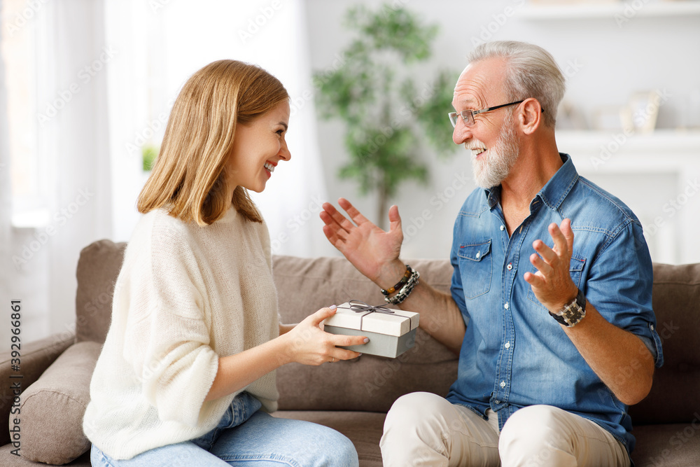 Happy woman giving present to father.