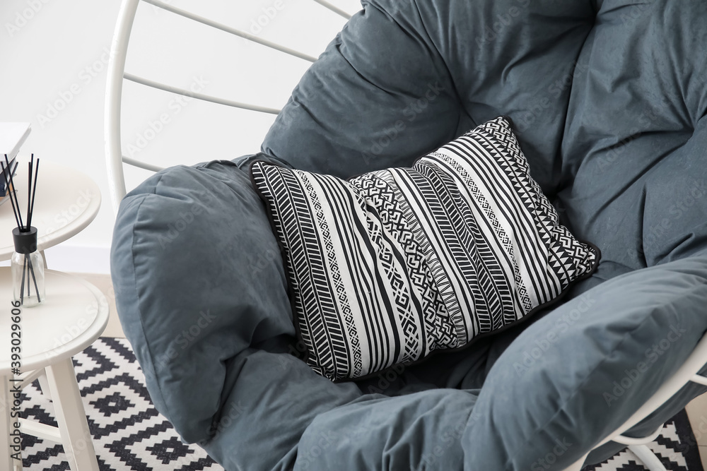 Stylish armchair with pillow in room