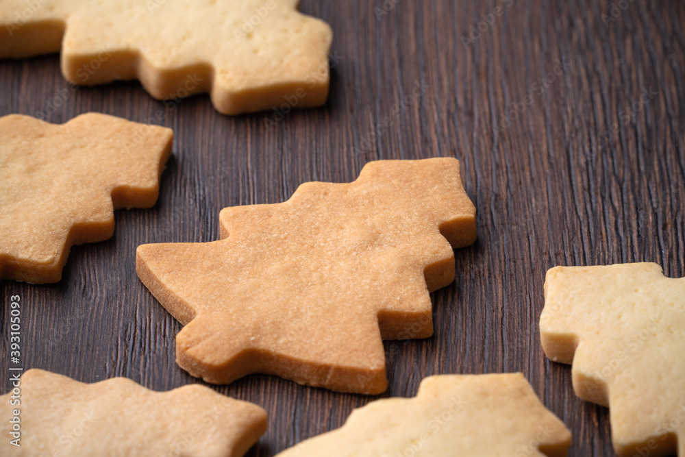 Close up of plain gingerbread Christmas tree cookie on wooden background.