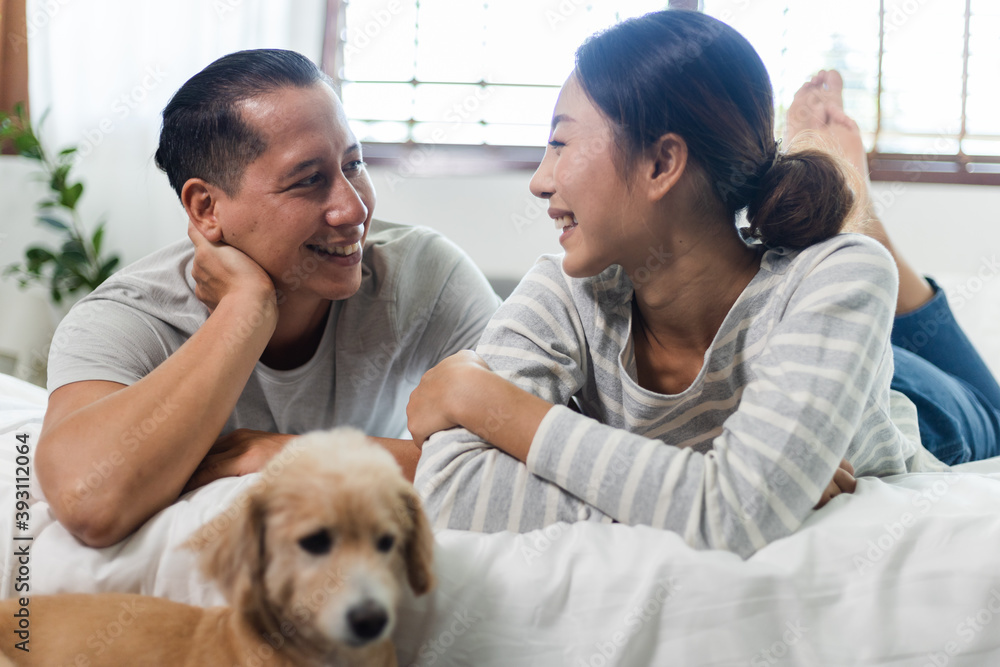 A young couple having a date at home smiling face with tenderness, looking in eyes to each. They are