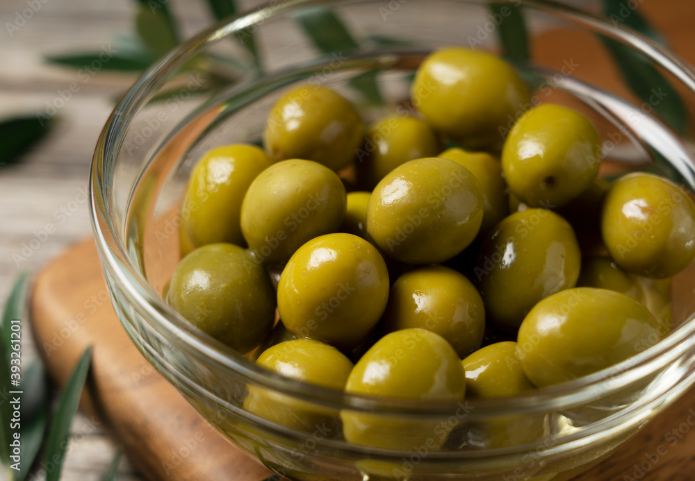 Olive branches with salted olives placed on a background of old wooden planks