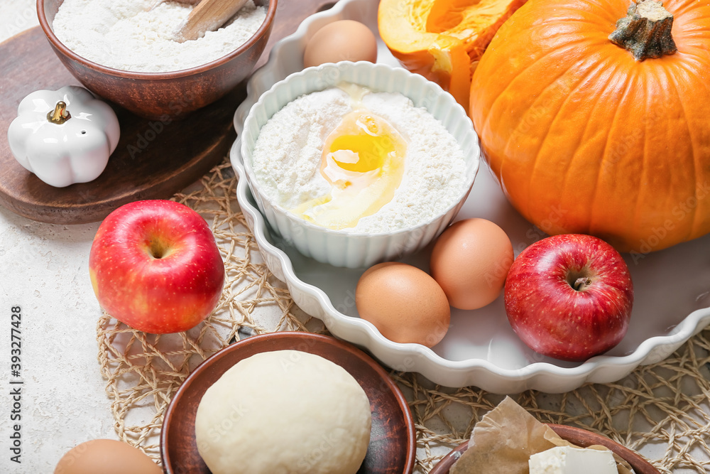 Ingredients for preparing pumpkin pie on light background