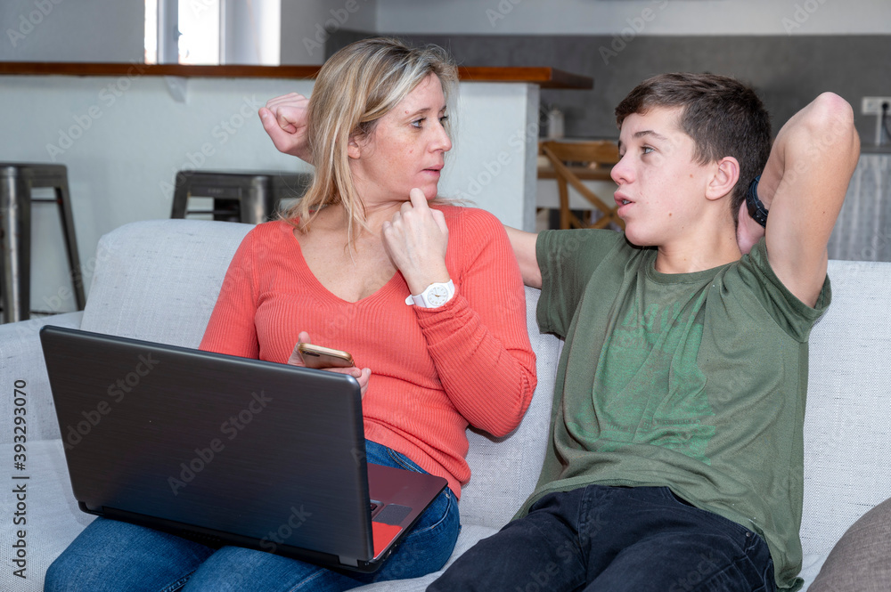 Adolescent et sa mère assis ensemble devant lécran dun ordinateur portable