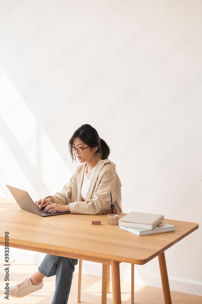 Studious Asian woman working at home using a laptop