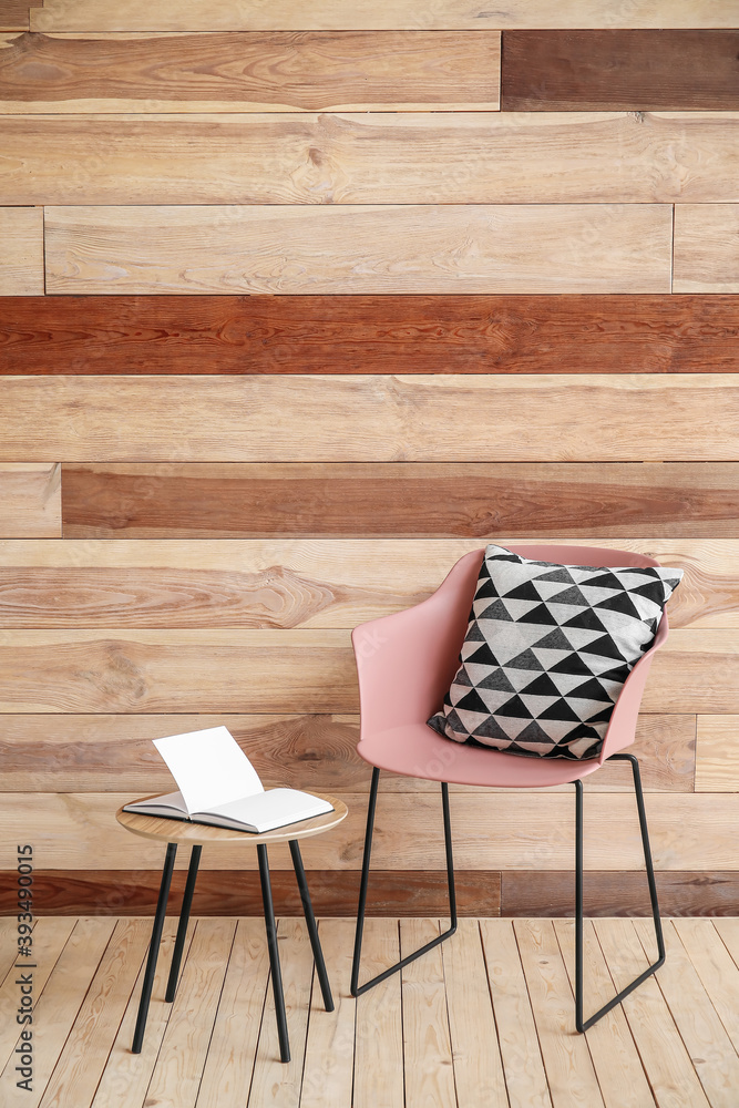 Chair and table near wooden wall in room