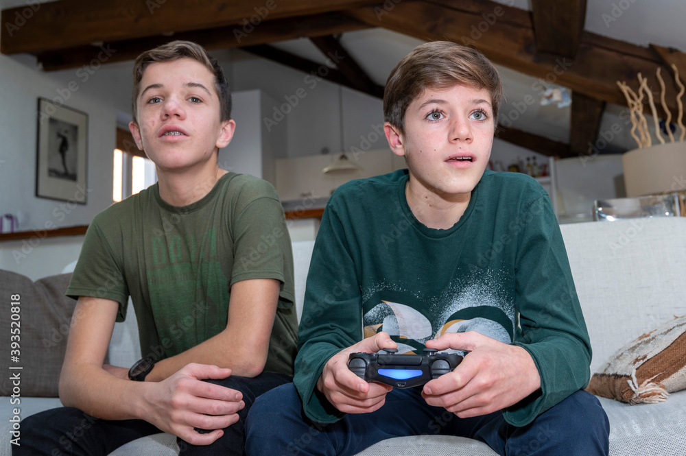 Adolescents jouant à la console de jeux à la maison