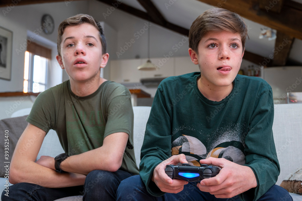 Adolescents jouant à la console de jeux à la maison