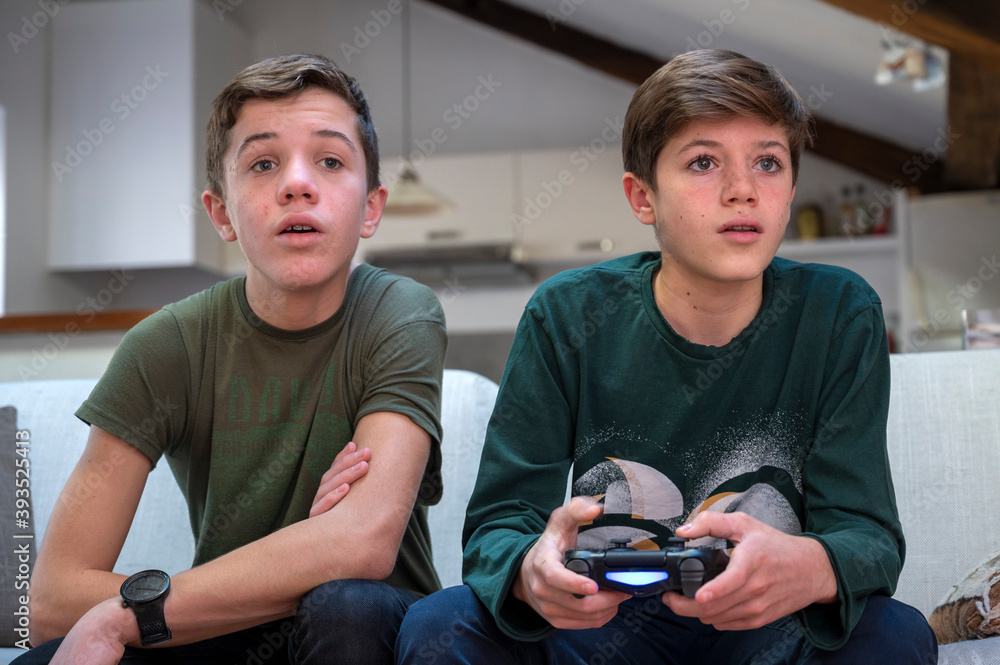 Adolescents jouant à la console de jeux à la maison