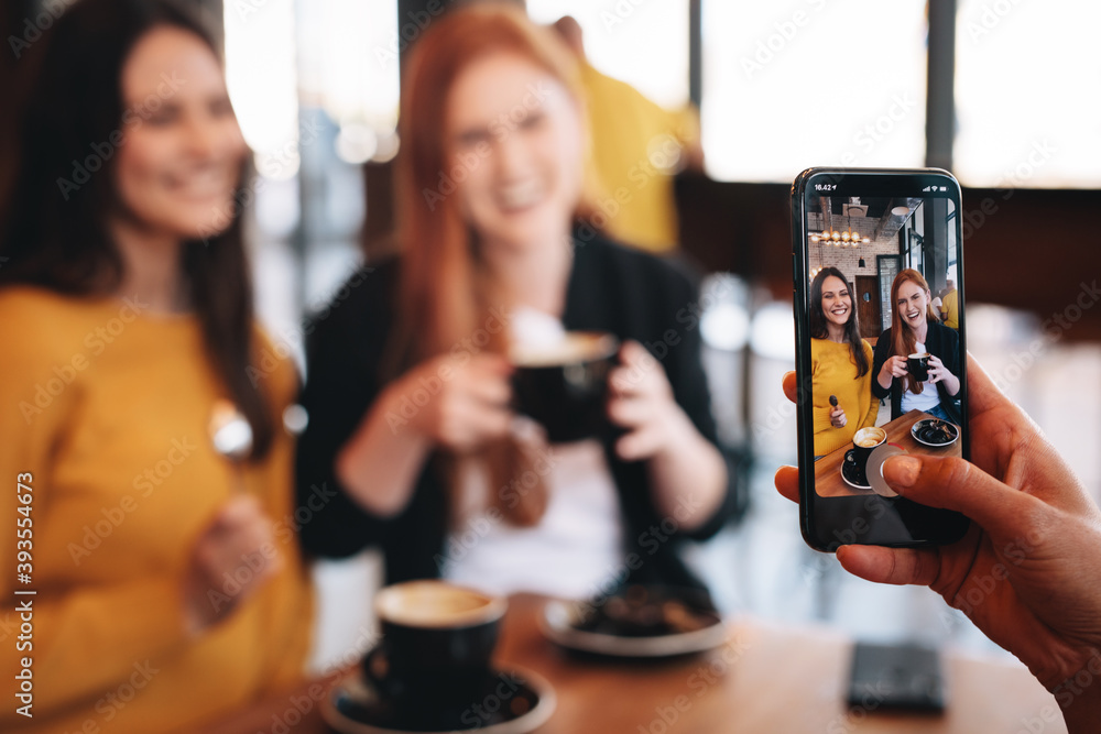 Friends being photographed at a cafe