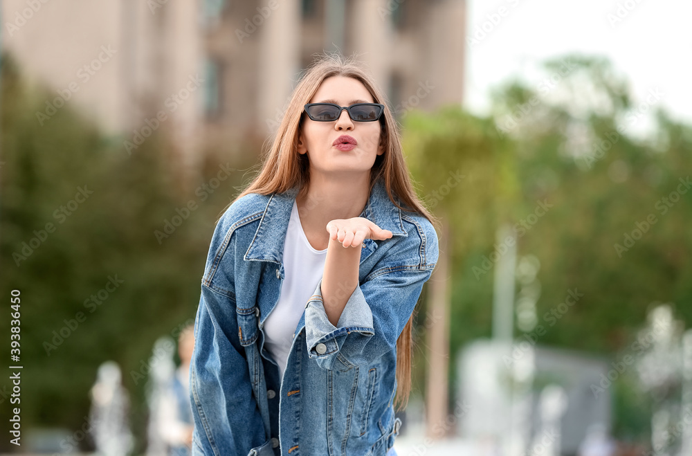 戴着时尚太阳镜的美女在户外飞吻