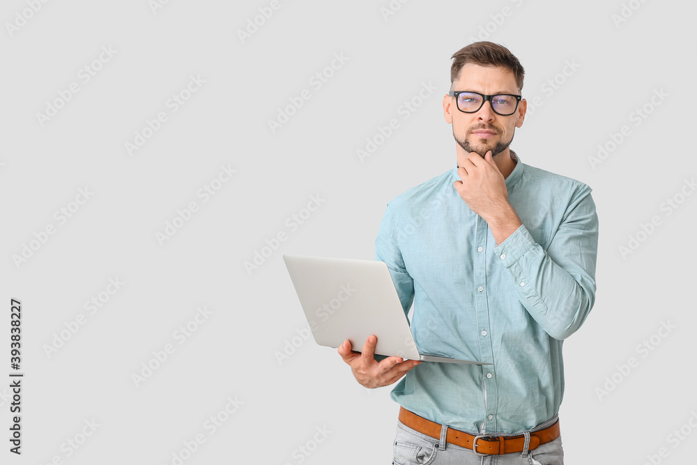 Male psychologist with laptop on light background