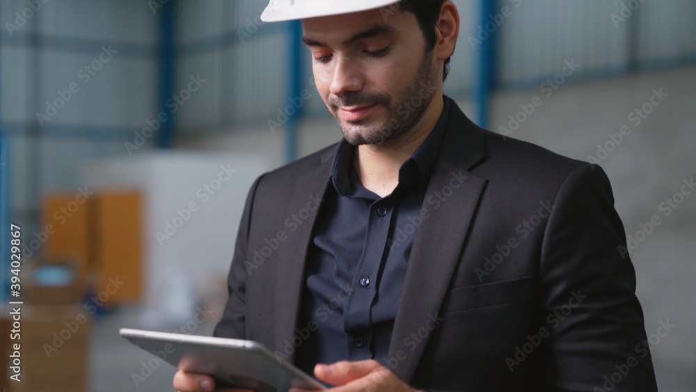 Factory manager using tablet computer in warehouse or factory . Industry and supply chain management