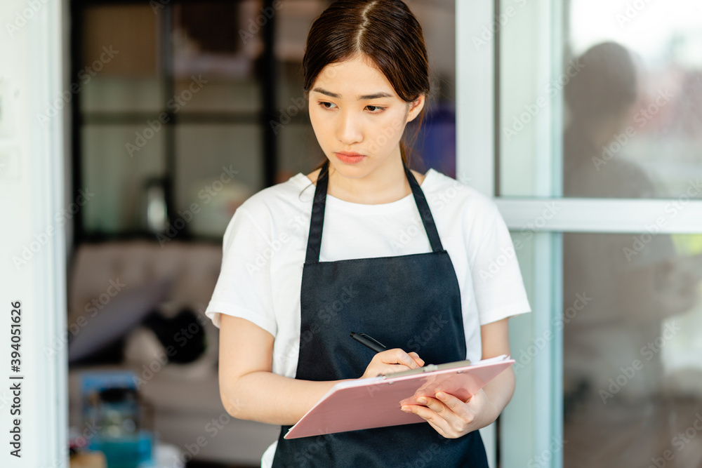 客人退房后，亚洲女服务员正在检查酒店房间