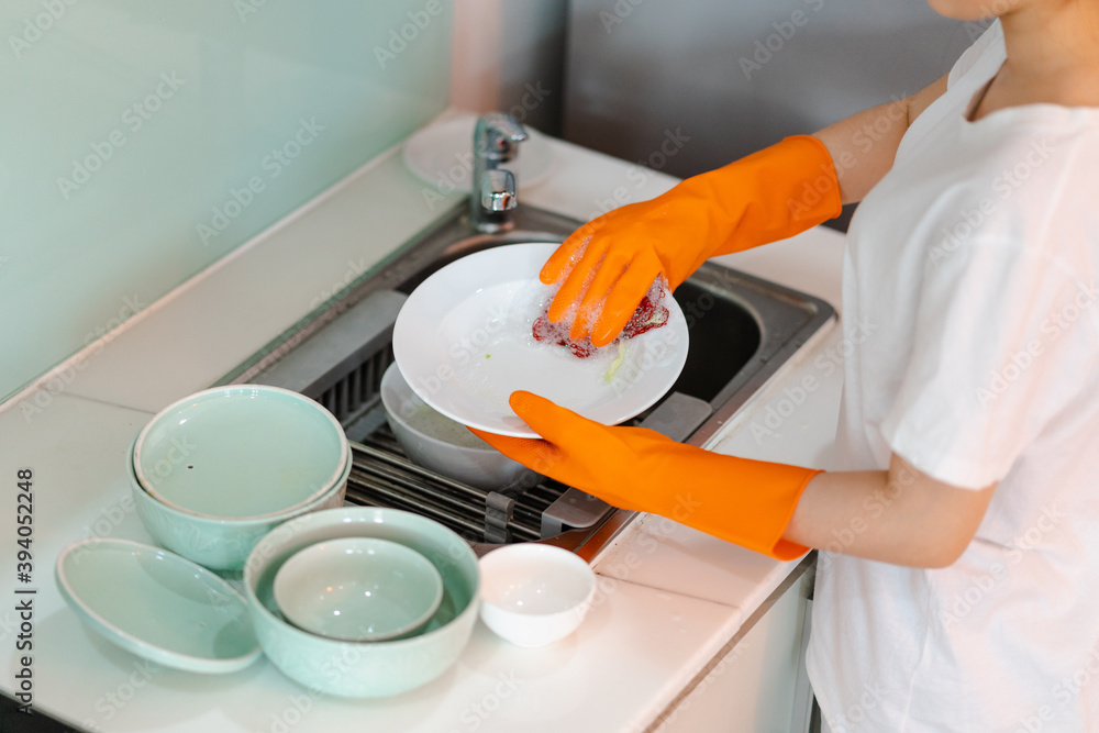 The Asian woman is washing the dishes