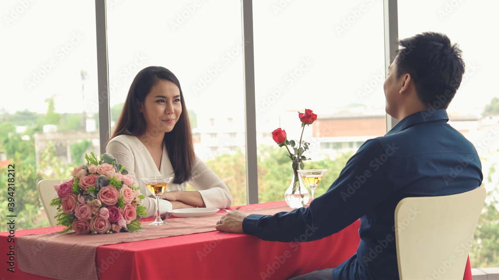 Romantic couple giving gift to lover at restaurant . Happy couple lifestyle .