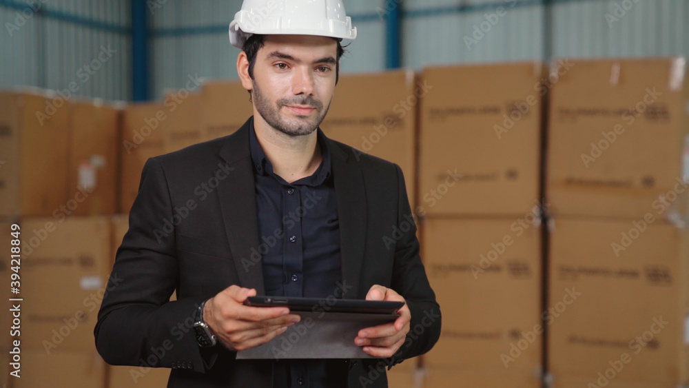 Factory manager using tablet computer in warehouse or factory . Industry and supply chain management