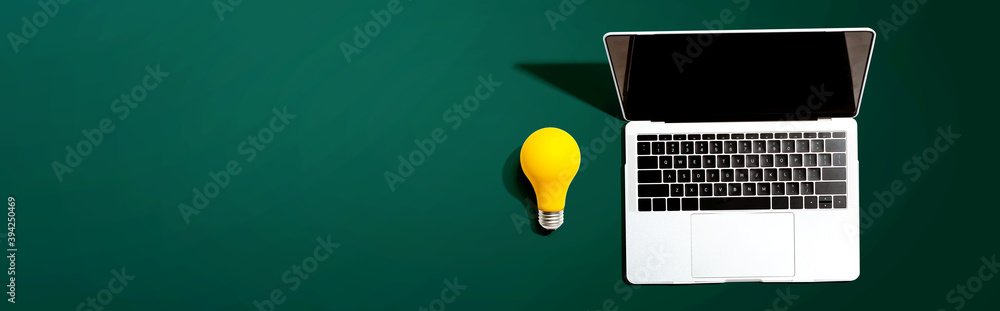 Laptop computer with a yellow light bulb from above