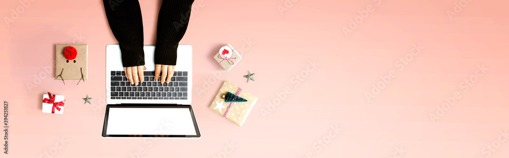 Person using a laptop computer with Christmas gift boxes from above