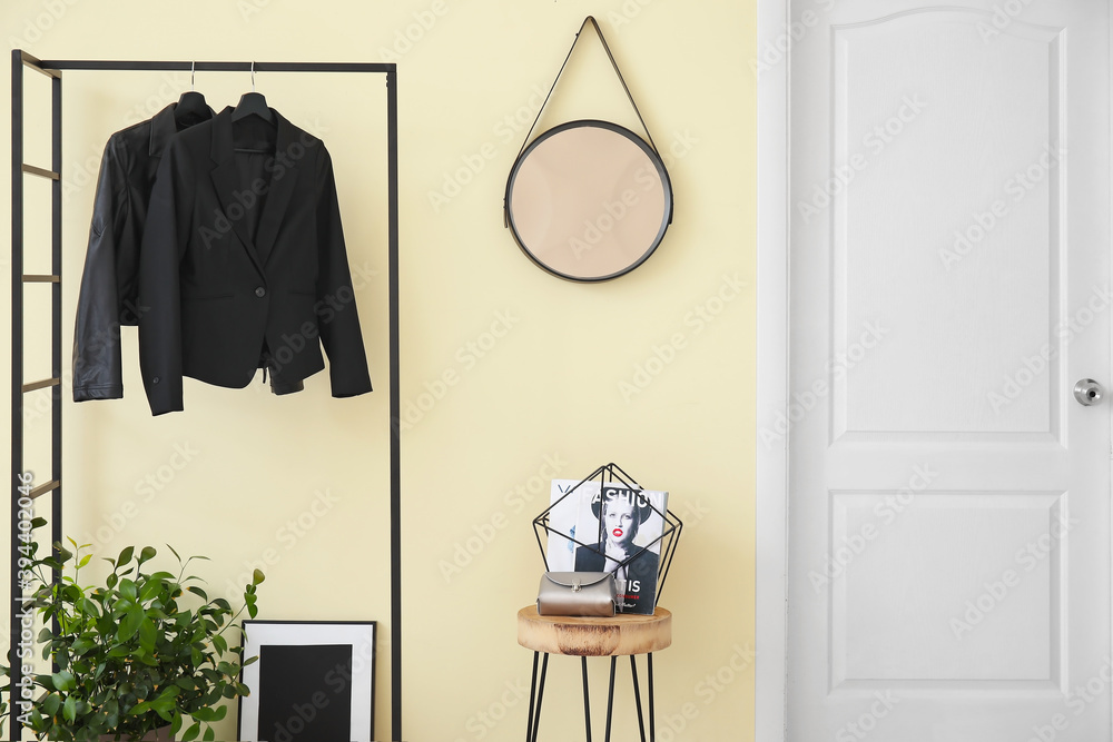 Stylish interior of modern hall with table and clothes rack