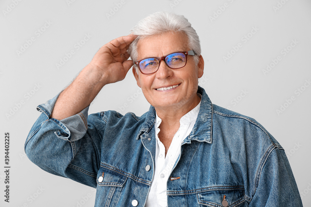 Stylish senior man on grey background