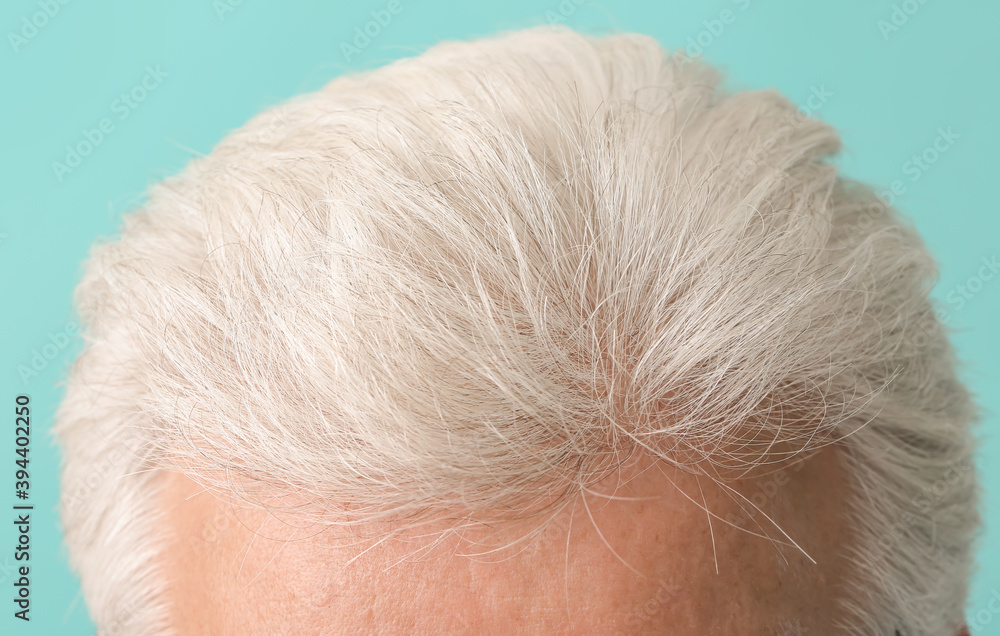 Senior man with grey hair on color background, closeup