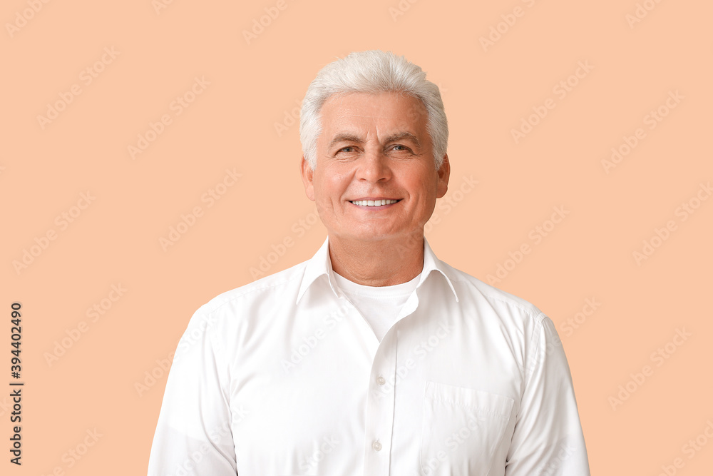 Stylish senior man on color background