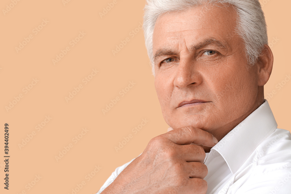 Stylish senior man on color background