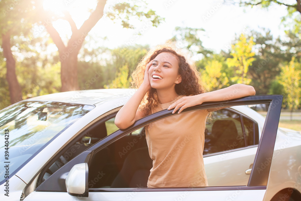 Happy African-American woman near car outdoors