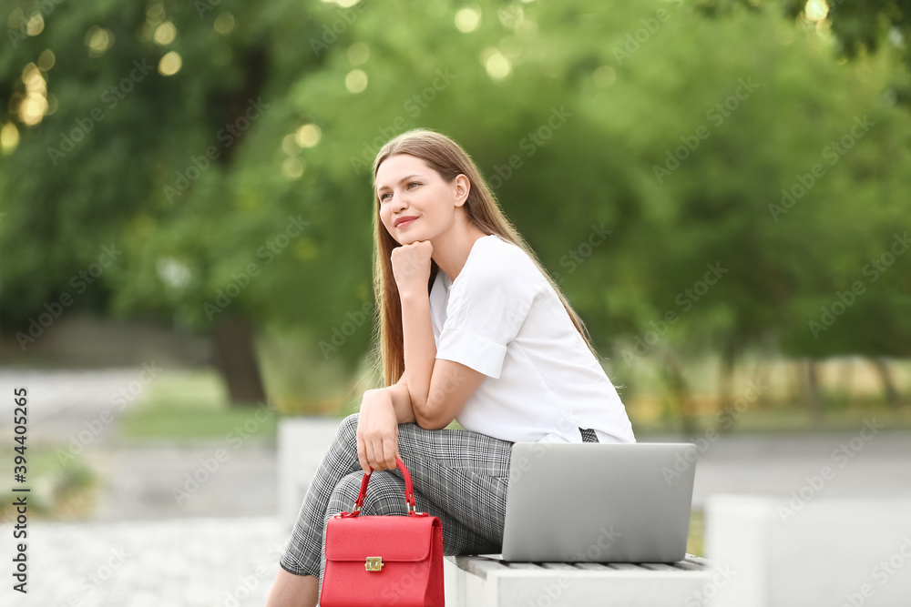 美丽的年轻女商人在公园放松